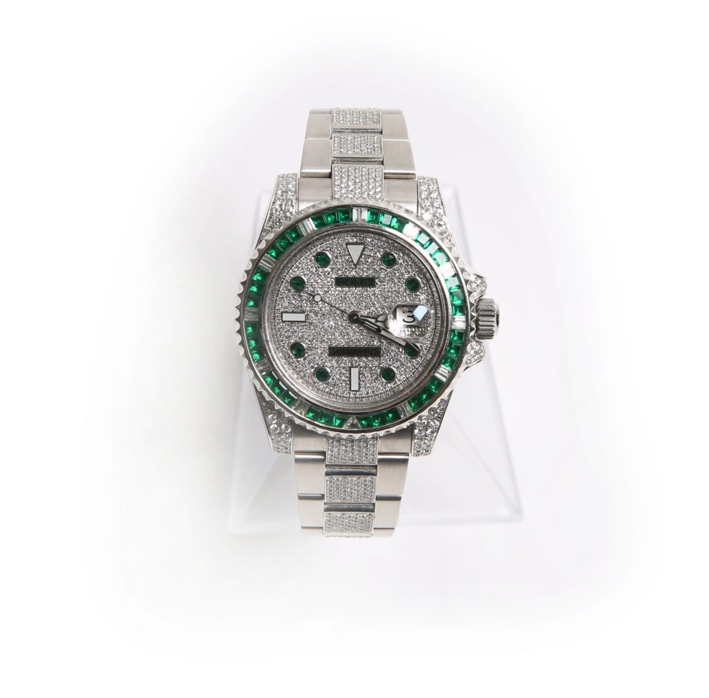 Rolex 116610 with custom set diamonds and emeralds