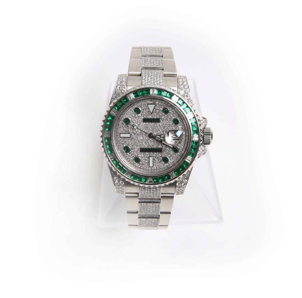 Rolex 116610 with custom set diamonds and emeralds