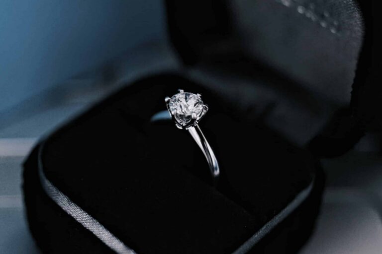 A round brilliant cut diamond solitaire engagement ring in a classic six-prong setting inside a black velvet box.